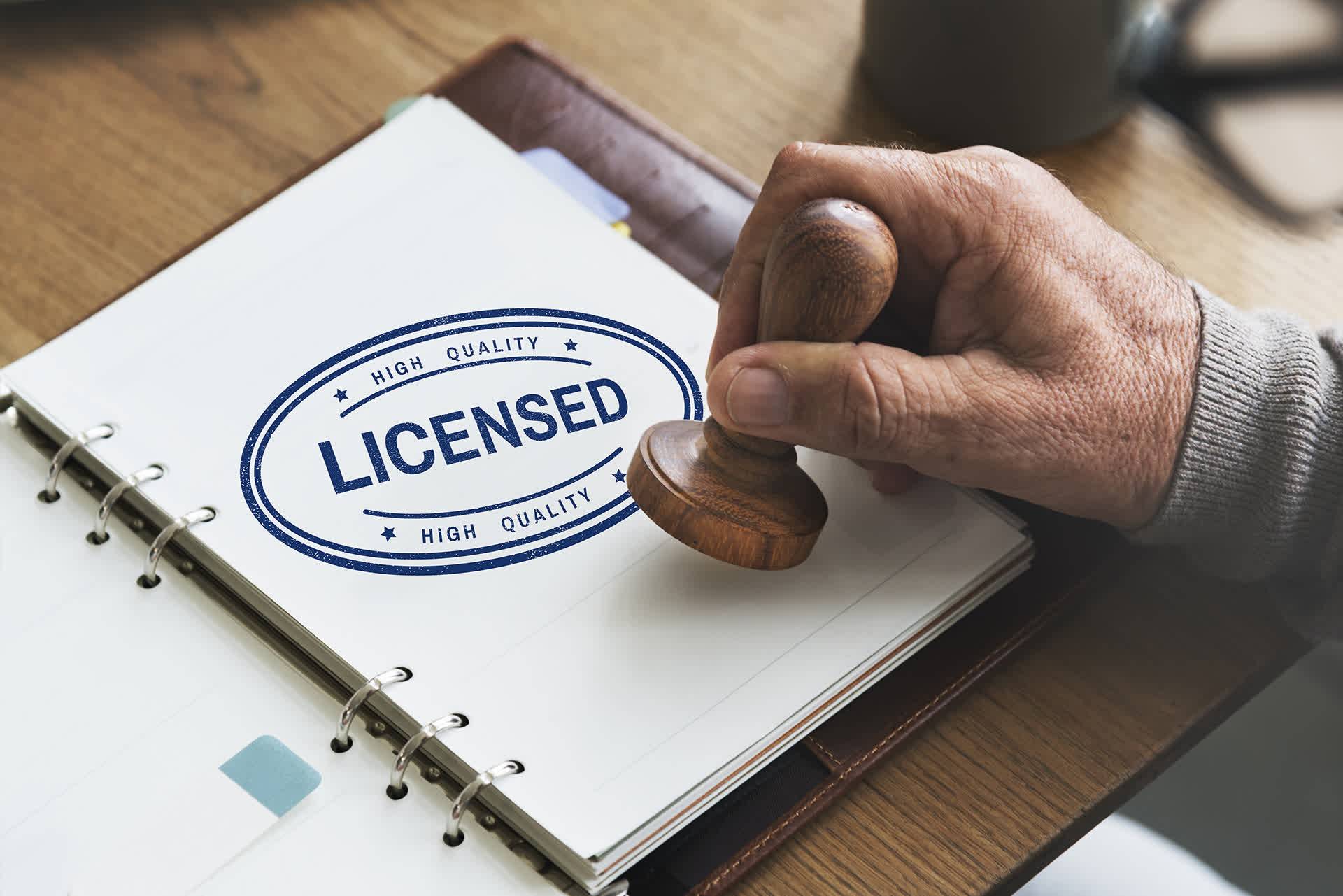 Mão idosa carimbando uma licença de produto controlado de folha branca Mão idosa carimbando uma licença de produto controlado de folha branca